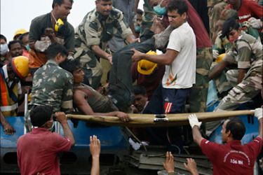 r_Indian soldiers and rescue workers carry an injured passenger from an overturned carriage of a train involved in an accident at Jhargram area in the eastern Indian state of West Bengal