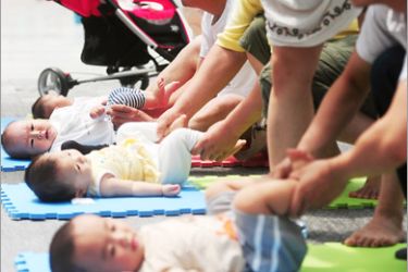 AFP - A group of Chinese parents help their babies exercise as they take part in an activity to celebrate the upcoming International Children's Day, in Beijing on May 31, 2010. The Chinese tradition of grandparents helping young couples with