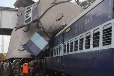 f_Indian rescue personnel conduct recovery operations on the mangled wreckage of train coaches following a railway accident in Sainthia, some 260
