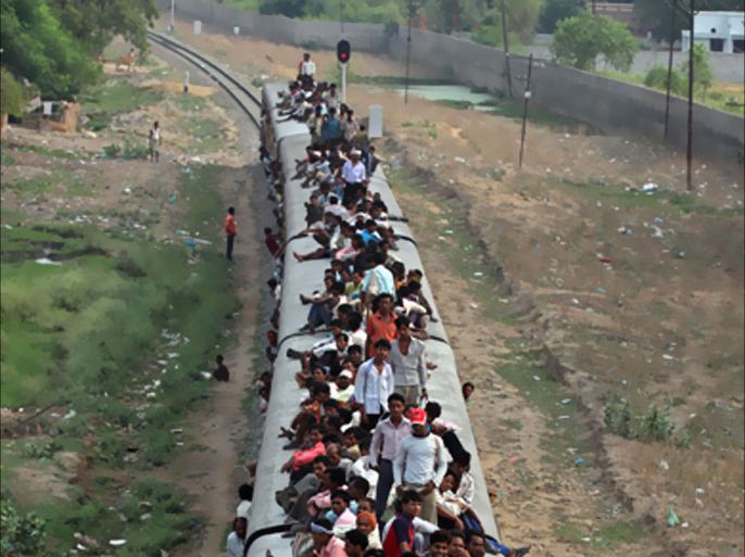 People travel on a crowded passenger train on the eve of "World Population Day" in the northern Indian city of Lucknow