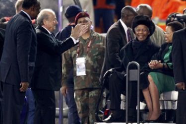FIFA President Sepp Blatter (2nd L) greets former South African President Nelson Mandela and his wife Graca Machel (R) at Soccer City stadium during the closing ceremony