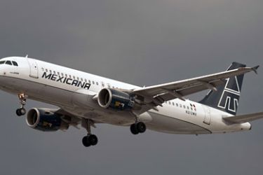 FILES) A Mexicana de Aviacion airliner flies over Mexico City on August 3, 2010. Mexican group "Tenedora K" acquired the 95 percent of the shares of "Nuevo Grupo Aeronautico", made up by Mexicana de Aviacion and its two subsidiaries, Mexicana Click and Mexicana Lin