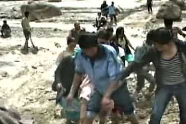 TELEVISION FRAME GRAB RESTRICTED TO EDITORIAL USE AND EDITORIAL SALES - MANDATORY CREDIT "AFP PHOTO/NDTV" This television frame grab taken from NDTV shows flood-affected residents walking through thick mud following flash floods in the remote Himalayan town of Leh on August 6, 2010