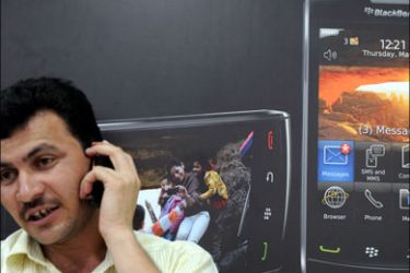 afp : (FILES) In this photograph taken on August 27, 2010, an Indian man speaks on his phone while sitting inside a BlackBerry phone store in Mumbai. india planned down-to-the-wire talks on Augyst 30, 2010, with the Canadian