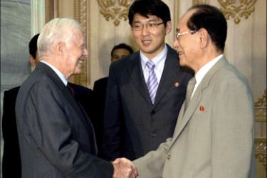 r : Former U.S. President Jimmy Carter (L) shakes hands with Kim Yong-nam, president of the Presidium of the Supreme People's Assembly of North Korea, during their meeting at the Mansudae Assembly Hall in Pyongyang August 25, 2010 in this