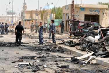 epa02277952 US soldiers and Iraqi policemen inspect the site of a bomb attack in Ramadi, 100 km (60 miles) west of Baghdad, Iraq on 08 August 2010. At least 7 people were killed and 25 others were wounded when a suicide bomber blew his booby-trapped car up in central