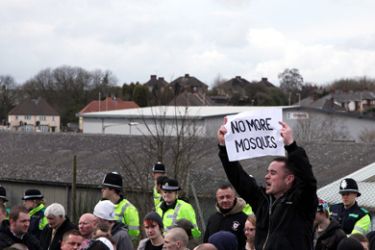 عنصري يرفع لافتة كتب عليها لا لمزيد من المساجد