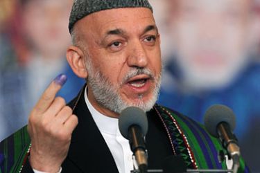 Afghan President Hamid Karzai gestures before casting his vote at a polling station in Kabul on September 18, 2010. Karzai cast his vote in the country's parliamentary election on September 18 amid tight security following a pre-dawn rocket attack on the capital, an AFP reporter said.