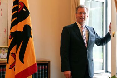 German President Christian Wulff stands at his office's window in the Bellevue Palace during a photo call in Berlin, Germany, 06 August 2010