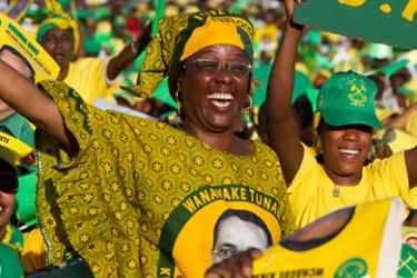 Supporters hold posters featuring Tanzanian President Jakaya Kikwete as their leader delivers a speechf/