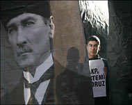 متظاهر يقف خلف صورة عملاقة لأتاتورك أثناء مسيرة مؤيدة لحظر الحجاب في أنقرة (رويترز-أرشيف) 