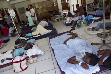 HAITI : People with cholera lie on mats on the floor of the overcrowded St. Nicholas Hospital in St. Marc, the center of the cholera epidemic