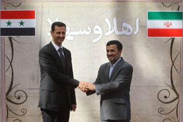 Iranian President Mahmoud Ahmadinejad (R) shakes hands with his Syrian counterpart Bashar al-Assad during a welcoming ceremony for the latter in Tehran on October 02, 2010. AFP PHOTO/ATTA KENARE
