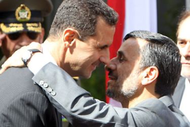 Iranian President Mahmoud Ahmadinejad (R) greets his Syrian counterpart Bashar al-Assad during a welcoming ceremony for the latter in Tehran on October 02, 2010. AFP PHOTO/ATTA KENARE