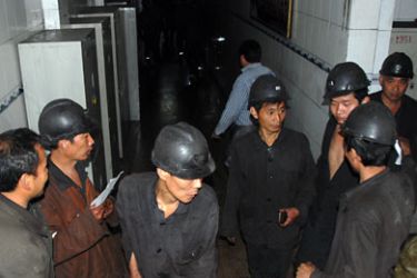 Some of the 239 miners that made it to the surface after the accident gather in the locker room at the mine in Yuzhou, central China's Henan province on October 16, 2010. Dozens of rescuers battled