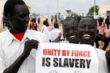 Southern Sudanese men hold a pro-independence poster as they waits for the arrival of envoys from the UN Security Council at the southern Sudanese capital Juba on October 6, 2010 who are on an official four-day visit to keep pressure on Africa's largest country to hold a