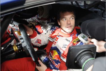France's rally driver Sebastien Loeb speaks to journalists at a check stop during the third stage of France’s new WRC round, Rally Alsace, on October 3,