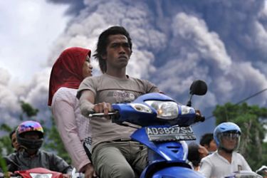 Local residents leave a danger zone as Merapi volcano releases ash clouds in Balerante village, Klaten on November 1, 2010. Indonesia's most active volcano which has claimed at least 36 lives last week spewed more searing clouds of gas and ash on October 31, triggering fresh panic among locals.