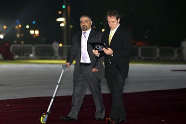 Gaz Deaves (R), Gaming Editor of the Guinness World Records, and a colleague measure a the largest jersey in the world in Doha on November 23, 2010