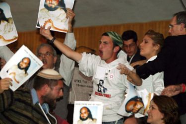 Unidentified protestors raise posters of Jonathan Pollard, an American jailed for spying for Israel in Washington DC, as they disrupt a speech by israelli Prime Minister Ariel Sharon