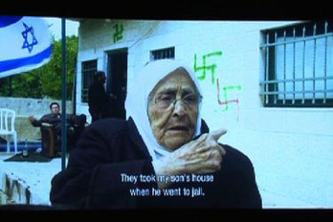 لقطة من الفيلم الوثائقي يعرض فيها امرأة تتكلم عن مصادرة بيتها