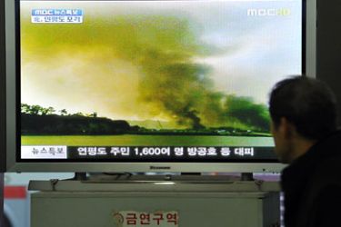 A South Korean man watches a public television screen broadcasting a report about North Korea's firing over the South Korean border island of Yeonpyeong near the tense Yellow Sea border, at a bus terminal in Seoul on November 23, 2010.