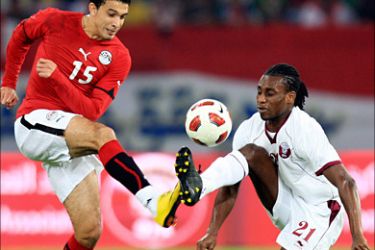 r_Qatar's Lawrance Quaye (R) fights for the ball with Mohamed Jeddou of Egypt during their international friendly soccer match in Doha December 16, 2010
