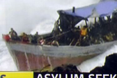 A Channel 7 TV framegrab of a photo released by The West Australian on December 15, 2010 shows a survivor (C) from an asylum boat full of refugees which was smashed by violent seas against the jagged coastline of Australia's Christmas Island
