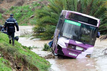 MOROCCO : Firefighters attempt to lift a bus that plunged off a road into a ravine during heavy rain in Bouznika, near Rabat on November 30, 2010. At least 18 passengers died. AFP PHOTO