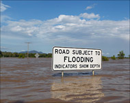 لافتة تحذيرية تدل على موقع الطريق الرئيسي المغمور بالمياه (رويترز)