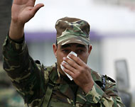 جندي تونسي يلوح بيده لكي تتوقف قوات الشرطة عن إطلاق الغاز المدمع  (الأوروبية)