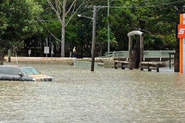 A submerged vehicle reappears covered in mud in the centre of Bundaberg as flood waters begin to recede on January 1, 2011.