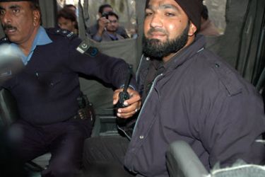 Arrested Pakistani police guard (R) sits in a police van at the site of a fatal attack on Salman Taseer, the governor of Pakistan's most politically important province Punjab