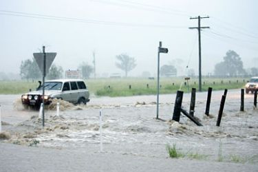 Traffic struggles through a flooded intersection at Thagoona in the Lockyer valley west of Brisbane on January 11, 2011.