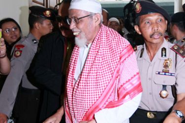 Indonesian cleric Abu Bakar Bashir (C) walks into the court room escorted by police during his trial in Jakarta, Indonesia on 14 February 2011. Indonesian cleric Abu Bakar Bashir goes to trial on terrorism charges that could lead to the death penalty four years after he was acquitted of links to the Bali bombings that killed 202 people.
