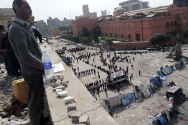 An Egyptian anti-government demonstrator keeps watch from the top of a building next the Egyptian Museum near stones ready to be thrown towards pro-regime opponents (not seen), at Cairo's Tahrir Square on February 4, 2011. Tens of thousands of protesters gathered for sweeping "departure day"