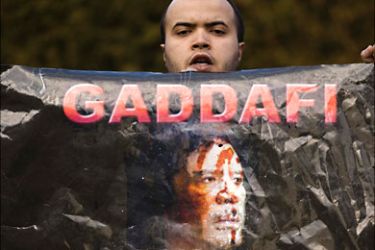 r_A protestor holds a placard depicting Libyan leader Muammar Gaddafi during a protest against Gaddafi and the Italian government outside the Italian embassy in Bern February 22