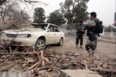 r_Afghan policemen inspect a car hit by a suicide car bomb attack in Khost province February 18, 2011. A suicide car bomb attack on a police checkpoint in eastern Afghanistan