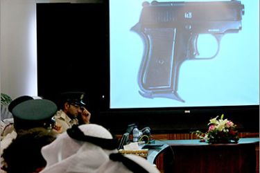 A image of a hand pistol is projected to journalists and police during a press conference by Dubai police chief Dahi Khalfan gestures during in Dubai bMarch 24, 2011 to