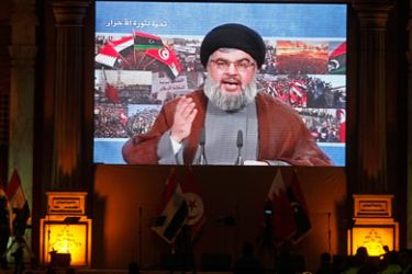 Lebanon's Hezbollah leader Sayyed Hassan Nasrallah addresses his supporters through a giant screen to express solidarity with the Arab uprisings and in support of their sacrifices, during a rally in Beirut's suburb, March 19, 2011.