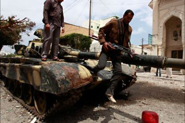r_A rebel fighter jumps off a captured Gaddafi forces tank at Tripoli street in Misrata April 22, 2011. Rebel fighters pushed Gaddafi forces off the upper part of Tripoli Street in central