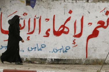 A Palestinian woman walks past graffiti reading in Arabic, “Yes to the end of the division”, in Gaza City on April 28, 2011 as Palestinians in the Gaza Strip and the West Bank welcomed reports that their rival Hamas and Fatah ruling factions had reached a political reconciliation understanding in Cairo.