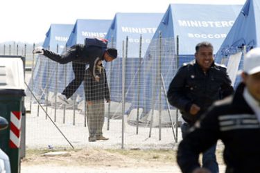 Tunisian would-be immigrants who were evacuated from the Italian island of Lampedusa to a reception centre in Manduria in the Puglia region, jump over the fence to escape from the camp on April 1, 2011. The Italian government has prepared a plan to accommodate 10,000 migrants on a temporary basis, before repatriating them to Tunisia
