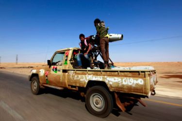 Rebel fighters ride atop a pick-up truck mounted with a rocket launcher, taken off helicopter gunships, in the front-line town of Ajdabiyah April 13, 2011. At the eastern front on Wednesday, rebels at Ajdabiyah said they were exchanging rocket fire with Muammar Gaddafi's forces from a point about 40 km (25 miles) east of the long contested oil port of Brega, which the government holds.