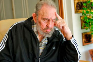 Former Cuban leader Fidel Castro reads a ballot paper before casting his vote during the Cuban Communist Party (PCC) 6th congress at his residence in Havana April 18, 2011.