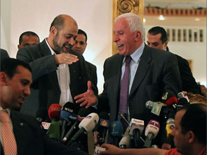 Palestinian Fatah delegation chief Azzam al-Ahmed (R) shares a laugh with Hamas deputy leader Mussa Abu Marzuq (L) as they prepare to shake hands after a joint press conference in Cairo on April 27, 2011
