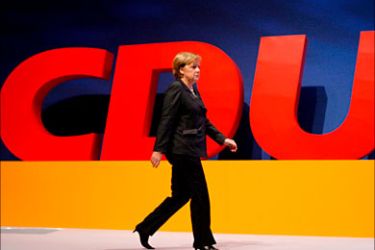 epa00871584 Angela Merkel, German Chancellor and chairwoman of the Christian Democrats (CDU), passes the CDU logo at the 20th CDU federal party congress