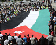 المتظاهرون يرفعون العلم الأردني الكبير في ميدان جمال عبد الناصر (الجزيرة نت)