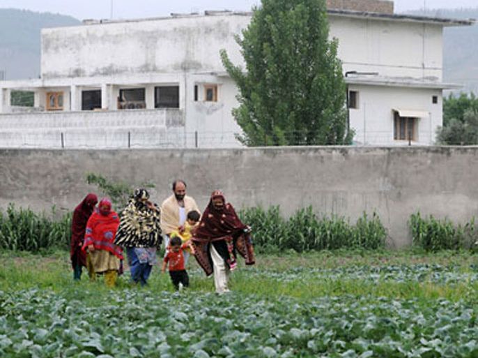 epaPakistani local residents pass behind the sealed compound in Abbottabad, Pakistan, on 05 May 2011, in which Osama bin Laden has been killed.
