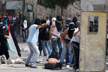 Masked Palestinian youths throw stones towards Israeli forces during clashes following Friday prayer in Arab east Jerusalem on May 13, 2011 as Israeli police flooded the streets of Jerusalem, fearing violence as Palestinians began marking the "Nakba" or "catastrophe" which befell them following Israel's establishment in